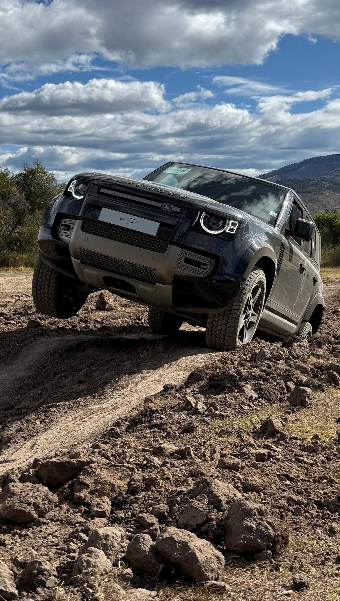 Land Rover Defender superando un obstáculo de tierra